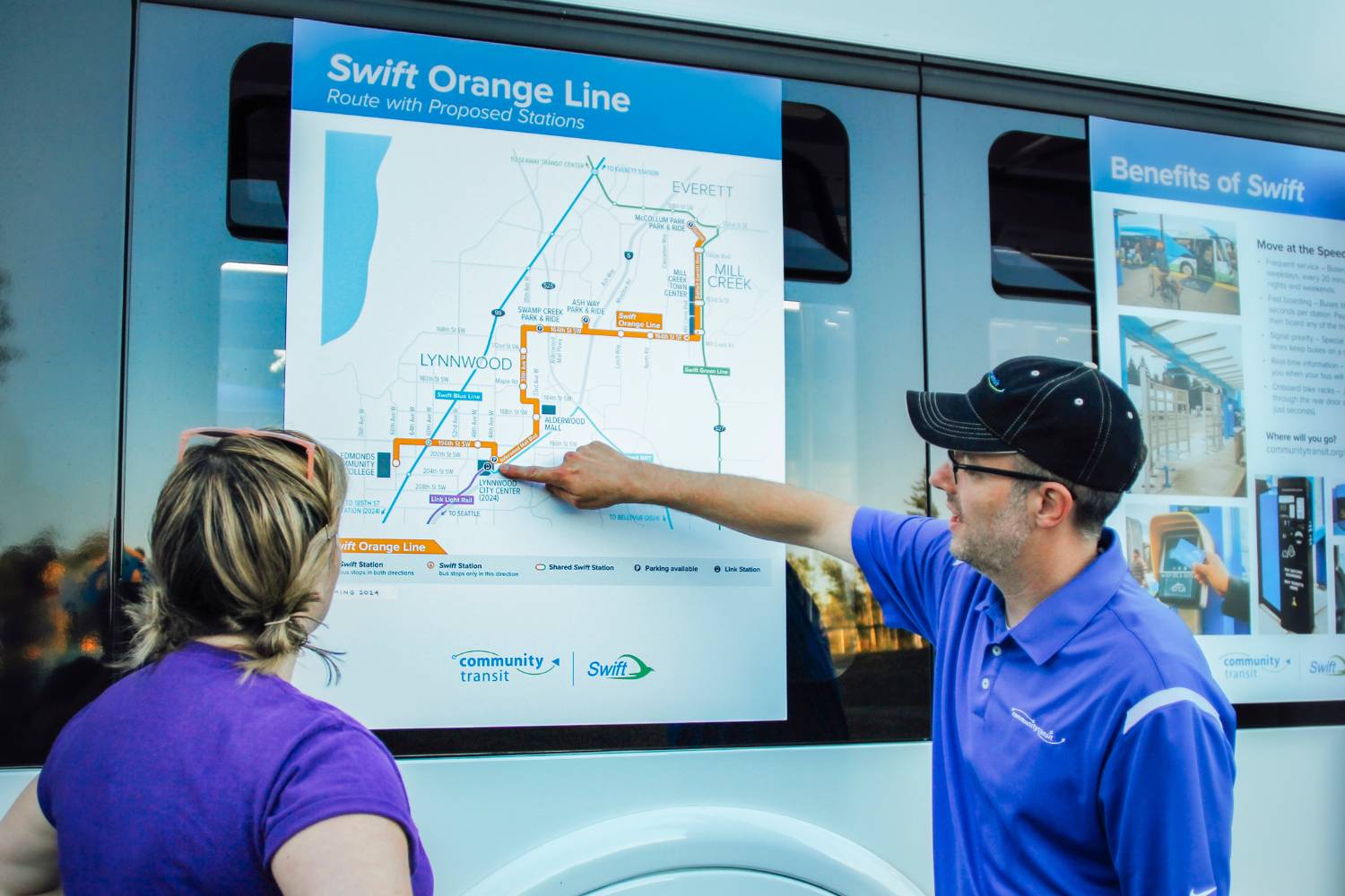 CT Staff members review a Swift Orange Line route map at a past outreach event.