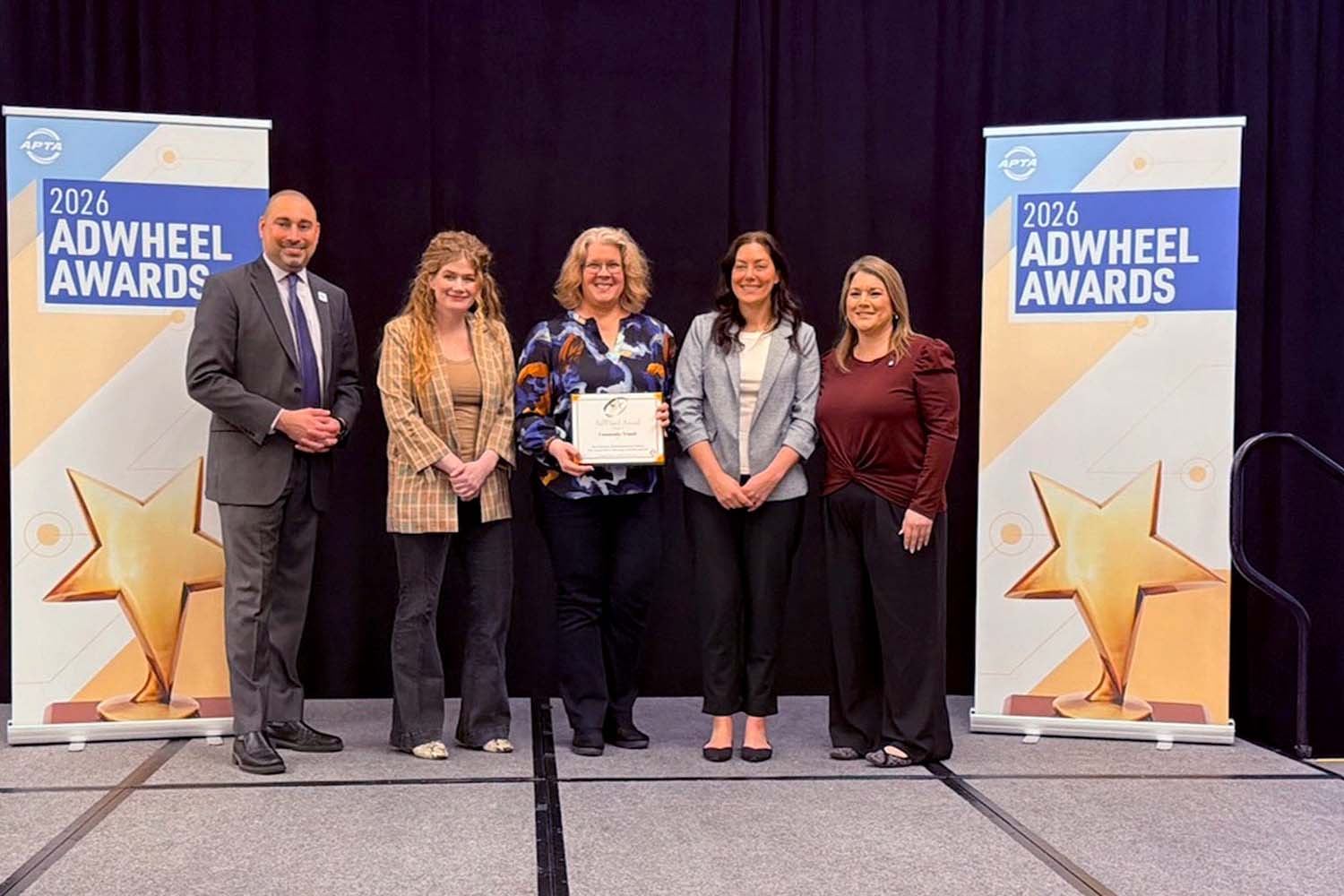Community Transit Marketing Director Jennifer Jeter (center) accepts award onstage at the 2026 APTA AdWheel Awards