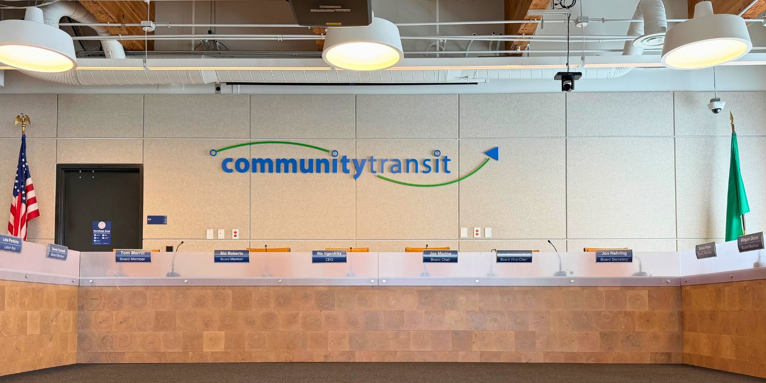 Community Transit board room with nameplates for board members, and the agency logo displayed on the wall behind.