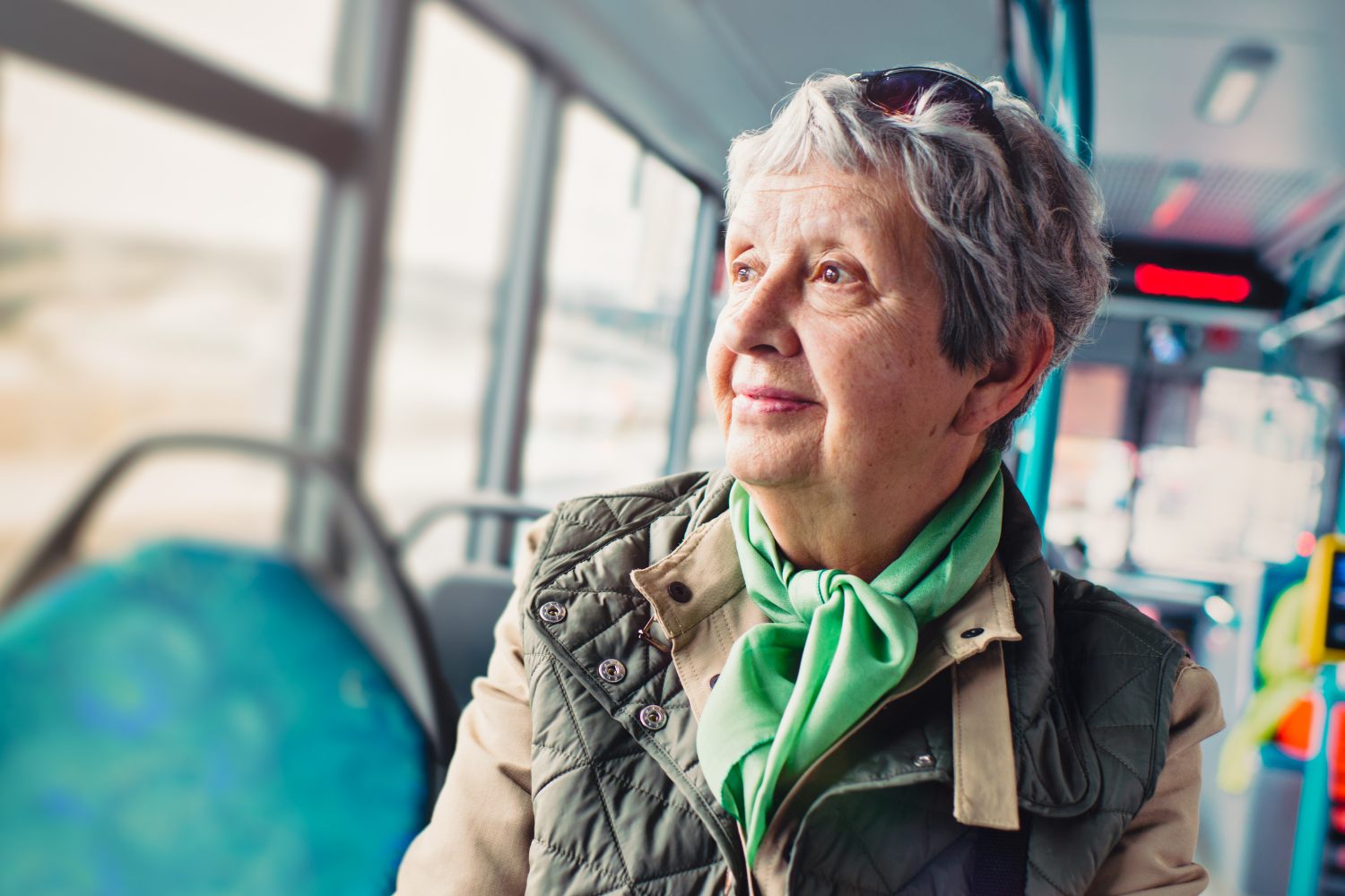 A woman looking out the window while riding the bus