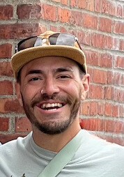 A man wearing a hat who is smiling.