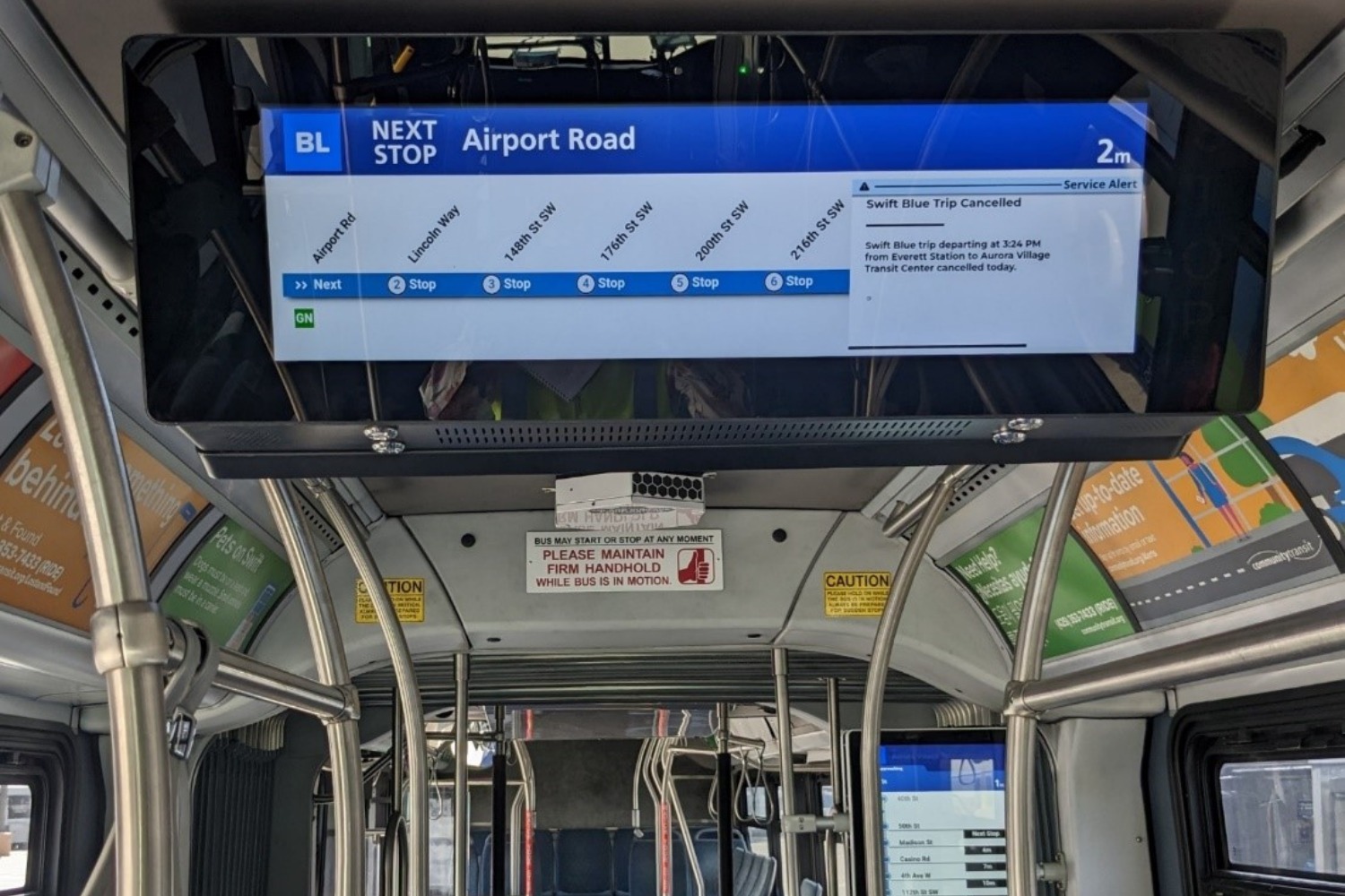 New digital onboard signage on a Swift bus shows real-time information and station locations.