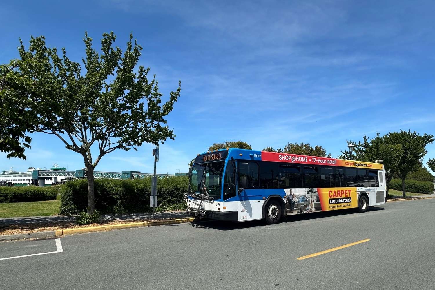 A bus parked at a stop at Edmonds Station. In the background, you can see a docked ferry boat.