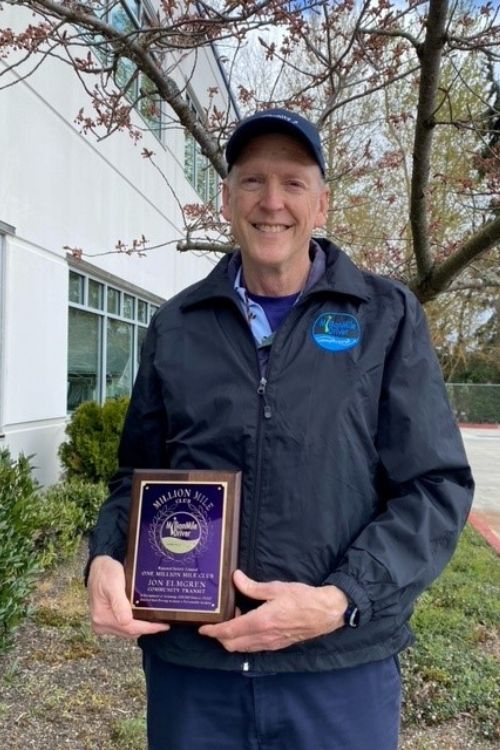 A man holds a Million Mile Driver plaque outside of the Community Transit operations base.