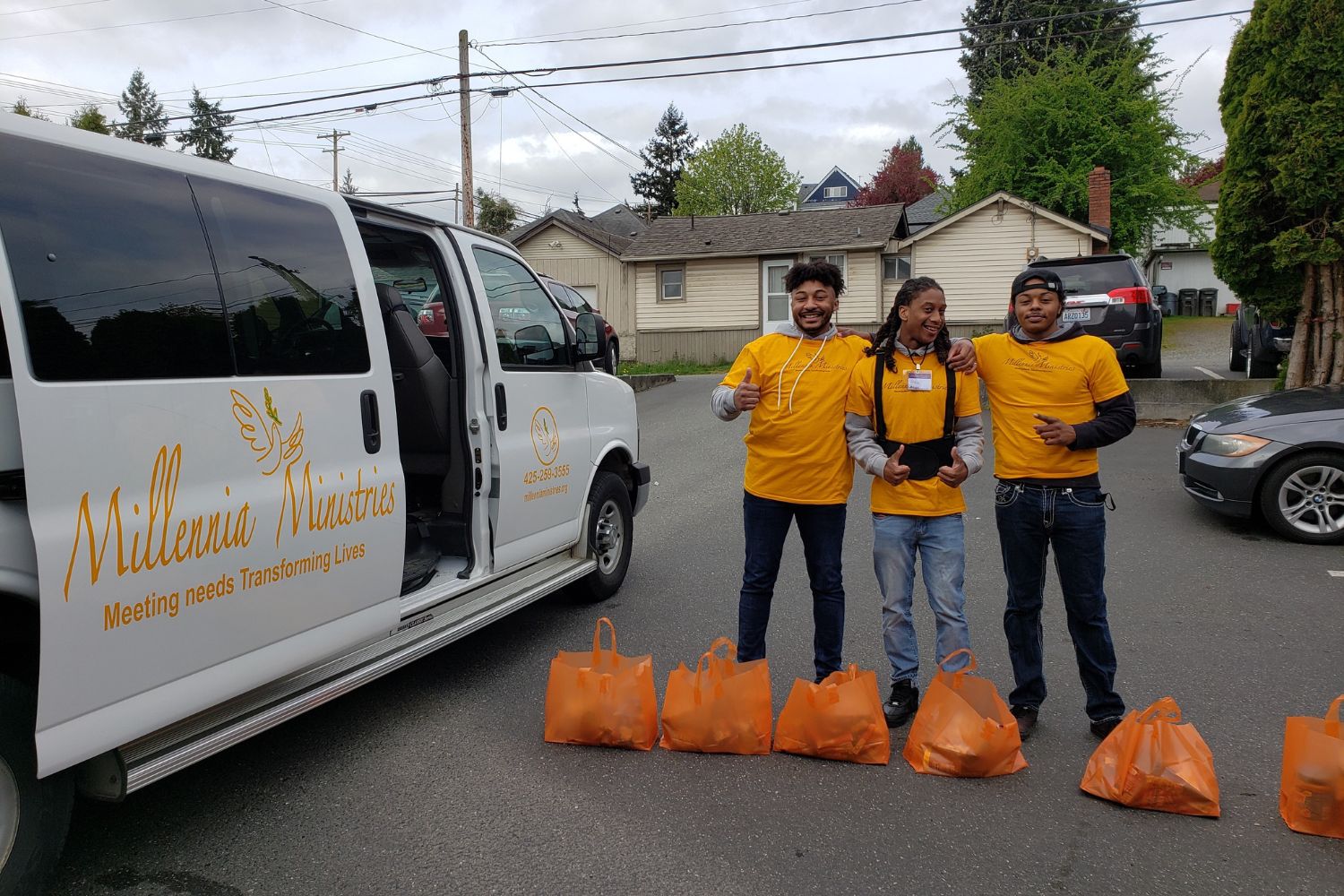 Volunteers smile while loading food donations into the van. 