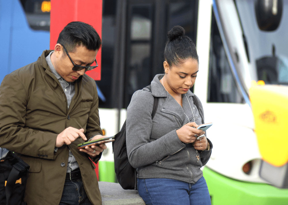 Riders checking routes before boarding the bus