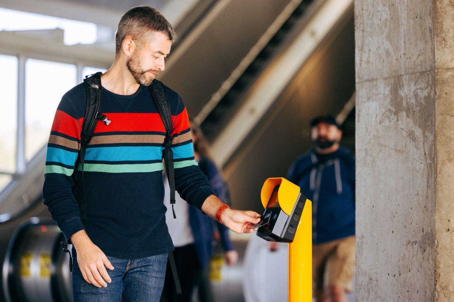 A man scanning an ORCA card at an ORCA card reader