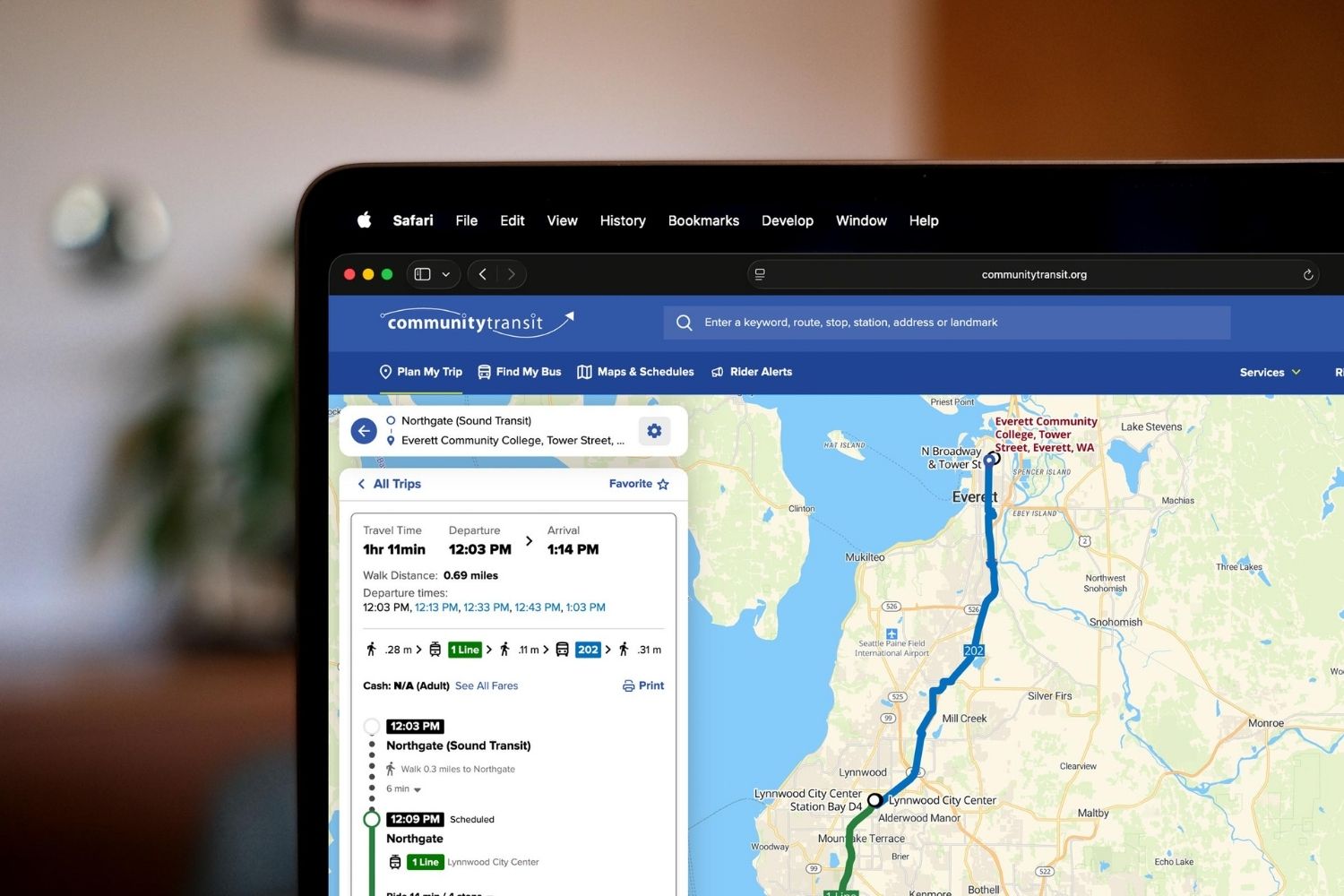 Plan My Trip Desktop 1 Laptop screen displaying the Community Transit website with the “Plan My Trip” tool open, showing a public transit route from Northgate to Everett Community College on a map of Snohomish County, along with travel time, departure, and arrival details.