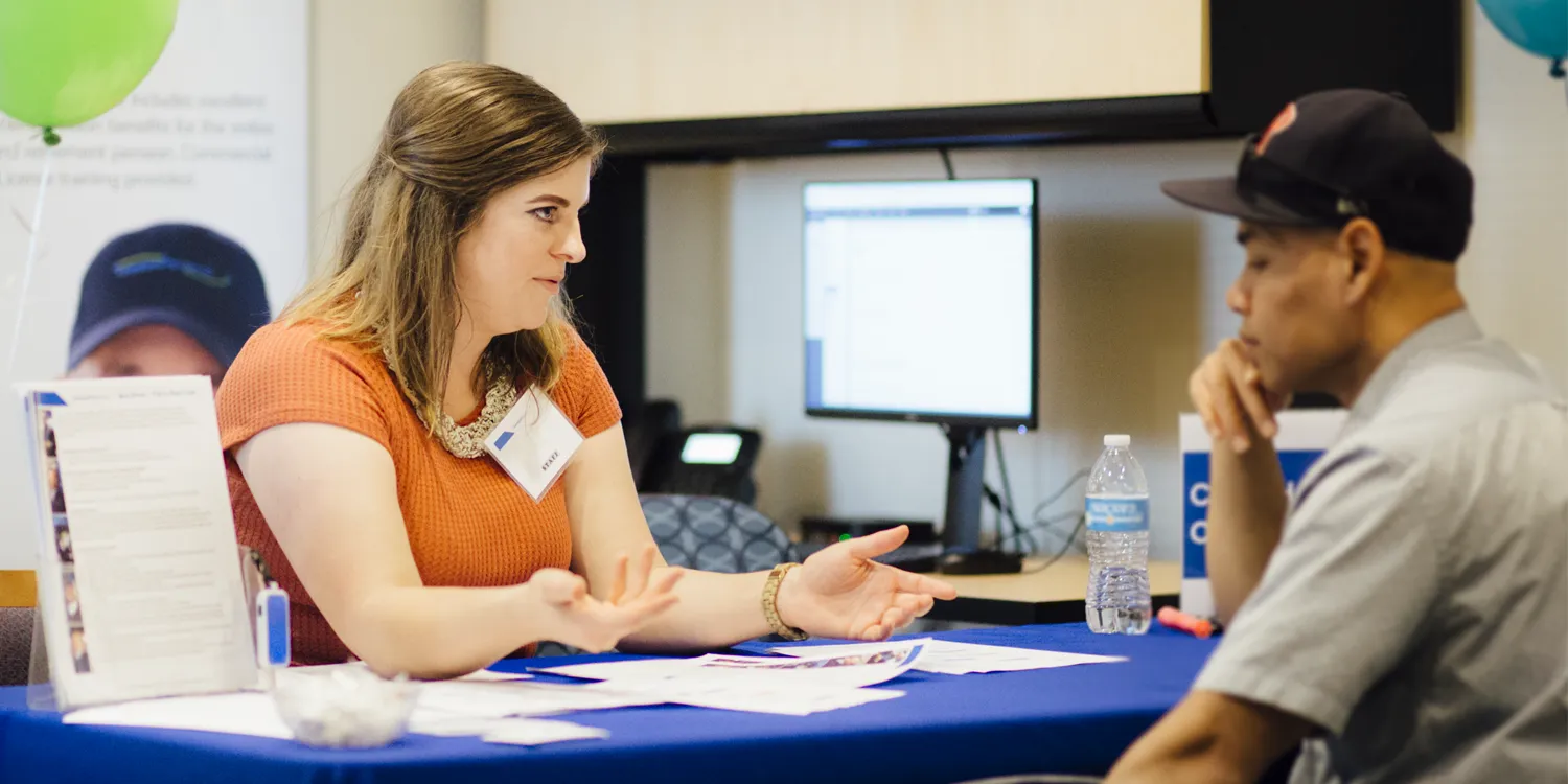 a CT employee sitting at a desk speaking with someone seated across from them