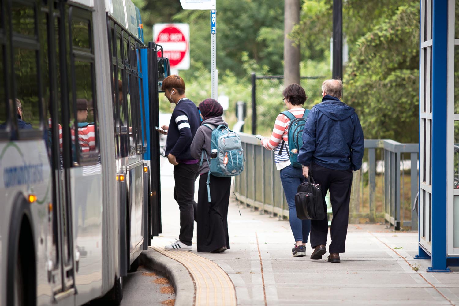 Men and women line up to board a bus at Mountlake Terrace Transit Center