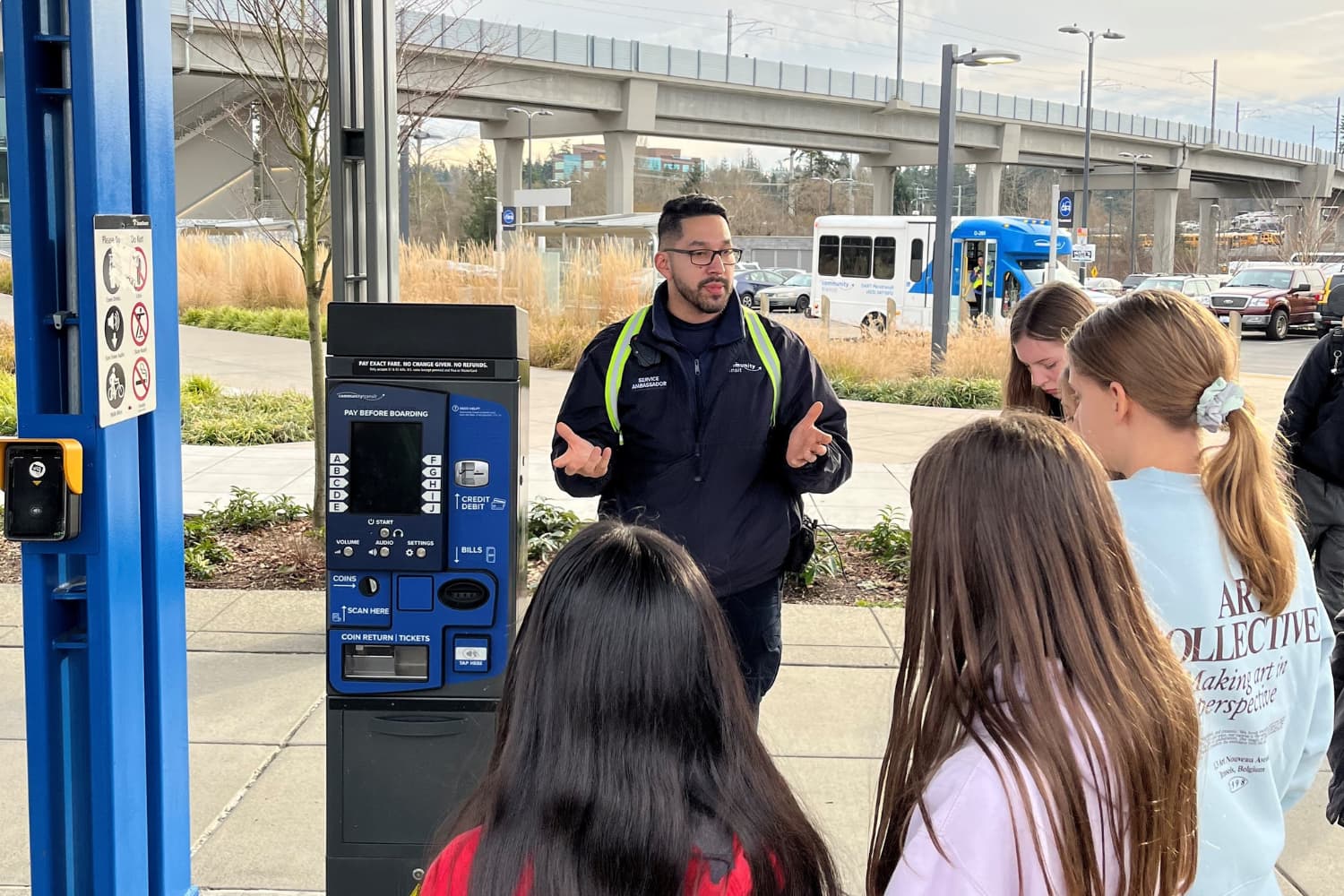 At Lynnwood City Center, CT service ambassador Alex explains to a group of teens how to pay transit fare.