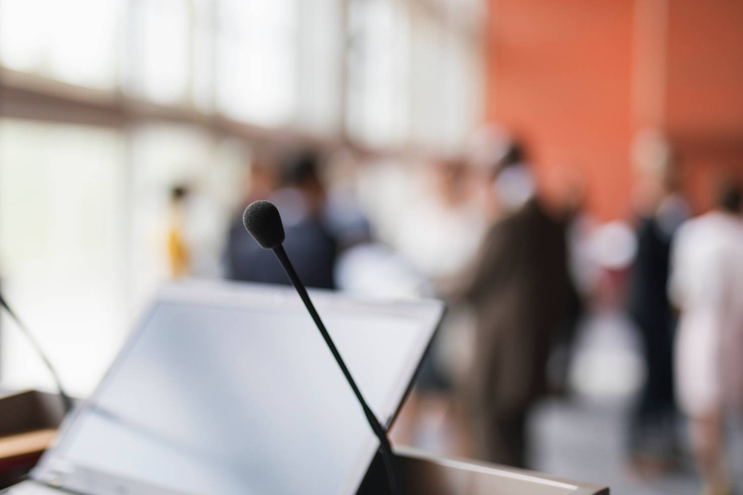 Community meeting with podium in the foreground, attendees are blurred in the background