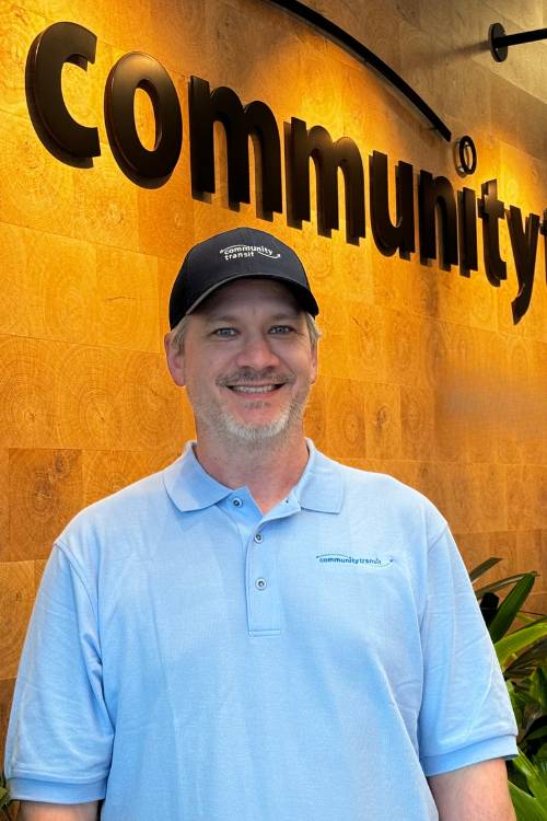 Headshot of Jason Lee, Swift coach operator. He is wearing a Community Transit uniform, standing in the lobby of the Cascade Administrative Building.