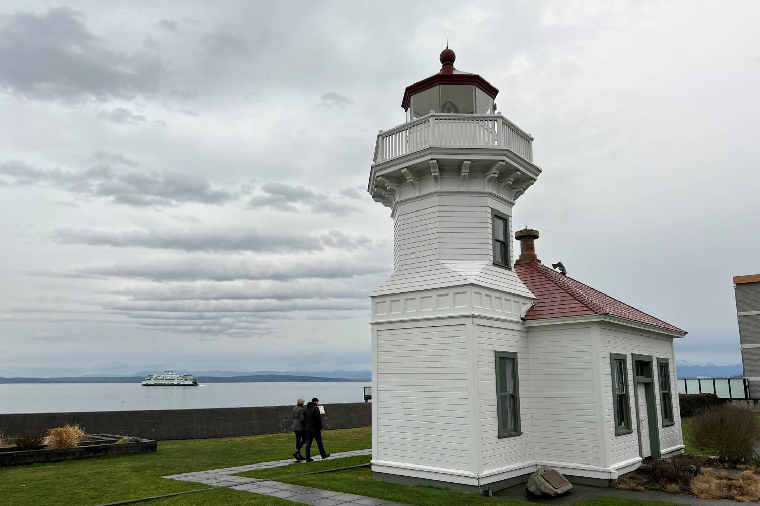 The lighthouse at Mukilteo Lighthouse Park in Mukilteo. A ferry sails in the distance.