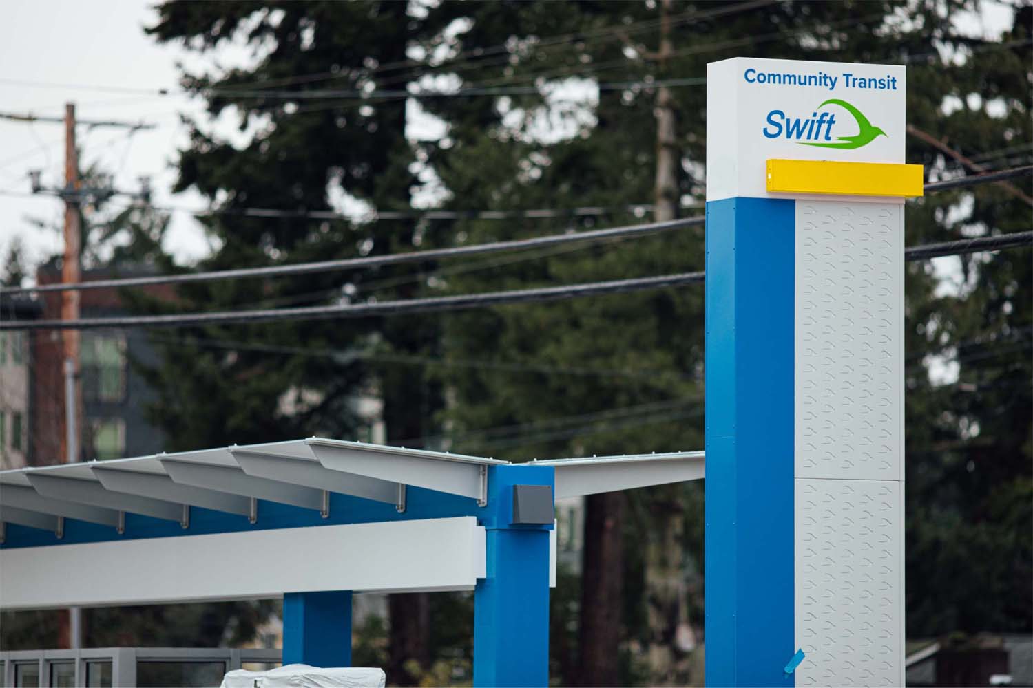 Photo shows what a Swift Gold Line station would look like with a yellow-gold bar on its station marker