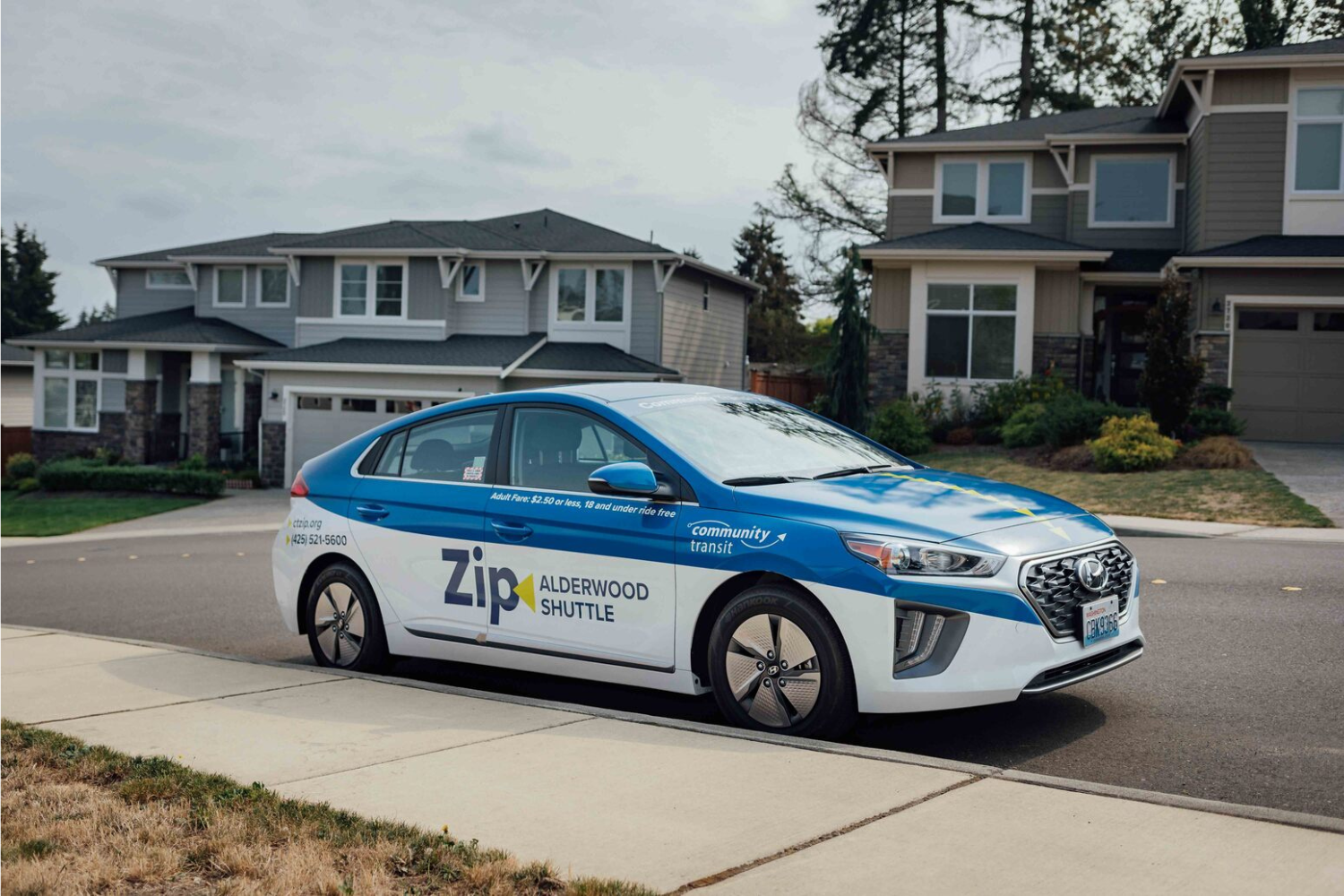 A Zip Alderwood Shuttle car parked on a residential street in Lynnwood, WA.