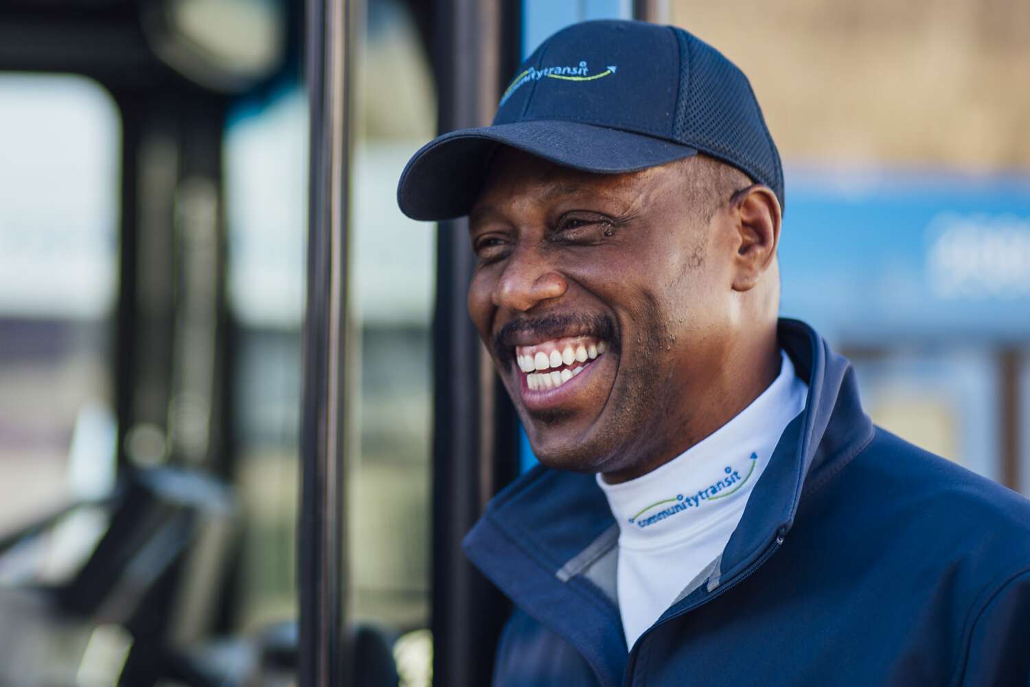 Bus Driver Robert Gaines is shown smiling in front of a CT bus.