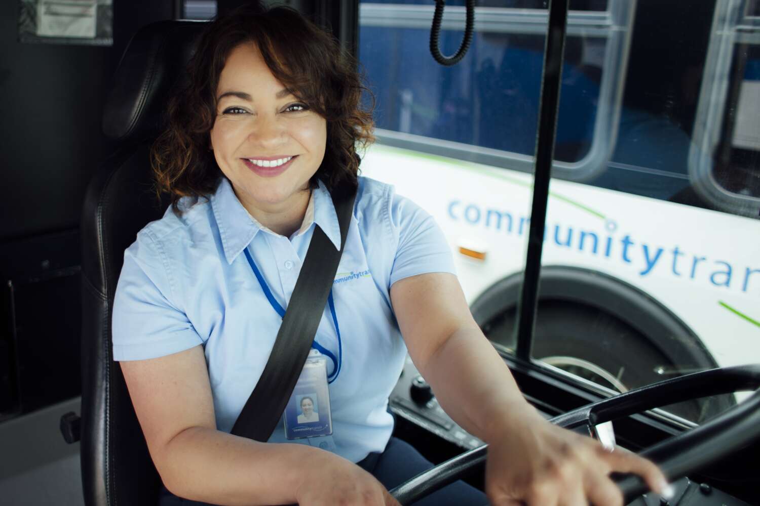 A CT bus driver smiles from behind the wheel.