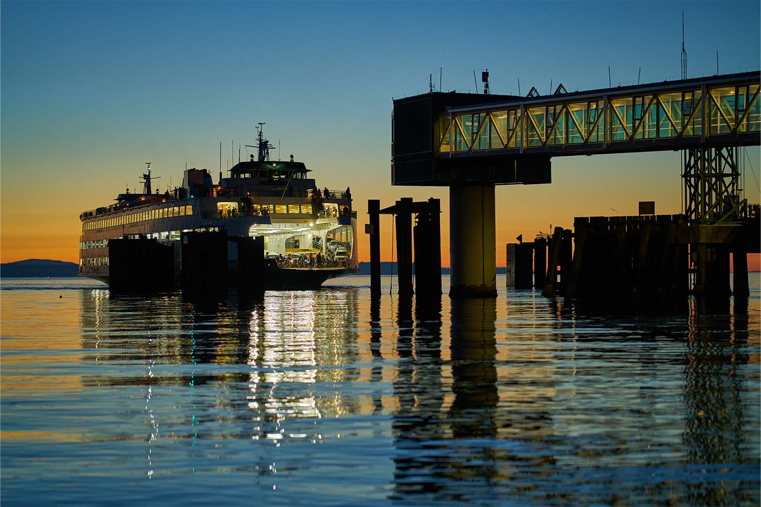 a ferry arriving at the terminal at dusk in Edmonds, WA