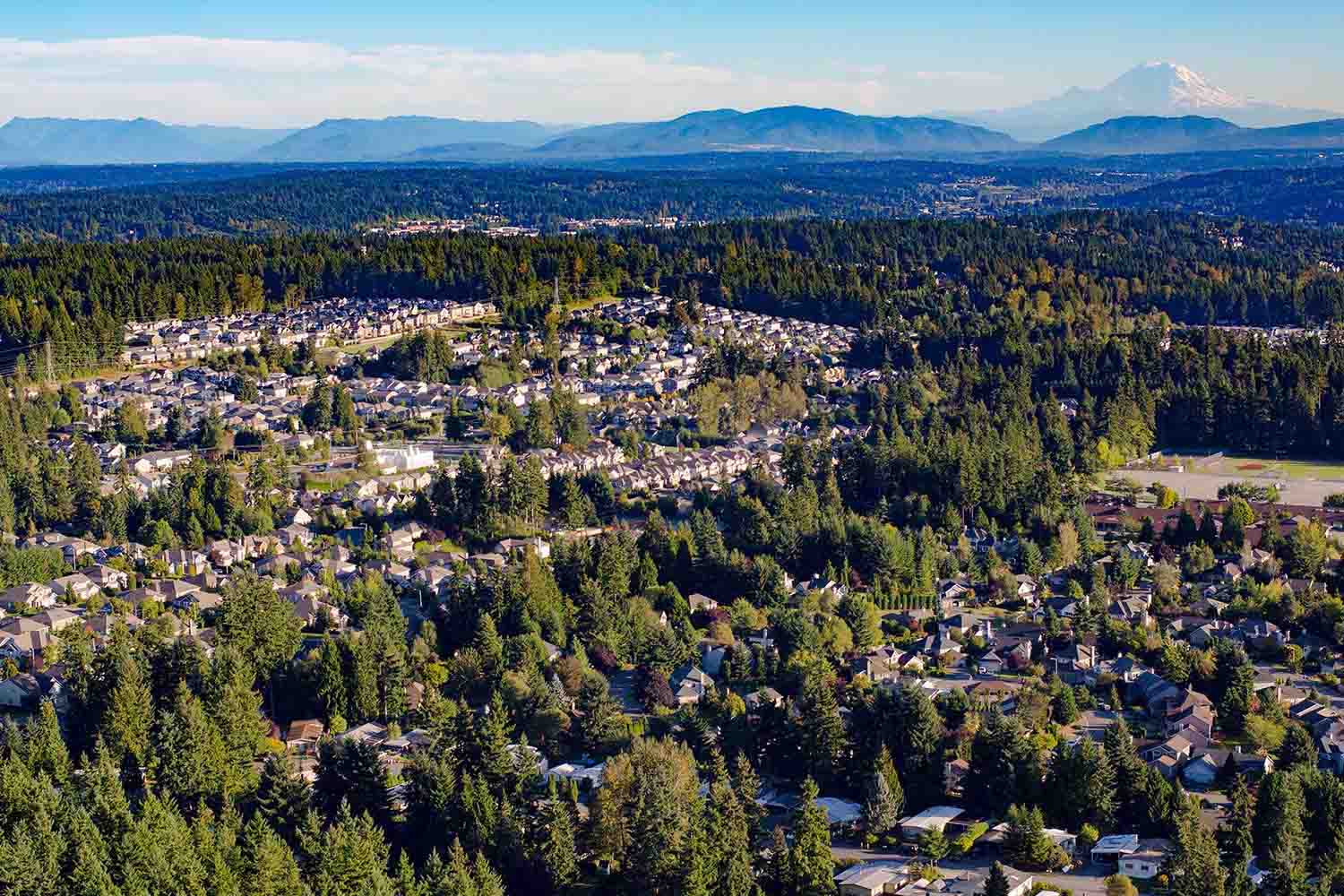an aerial photo of Mill Creek, WA with mountains in the background