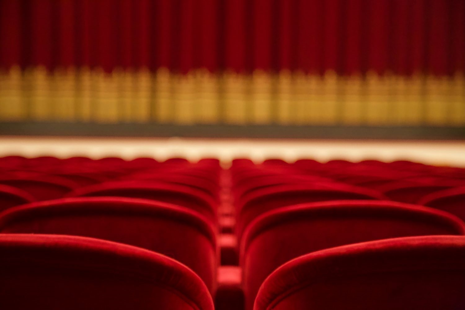 rows of seats in front a stage in a theater