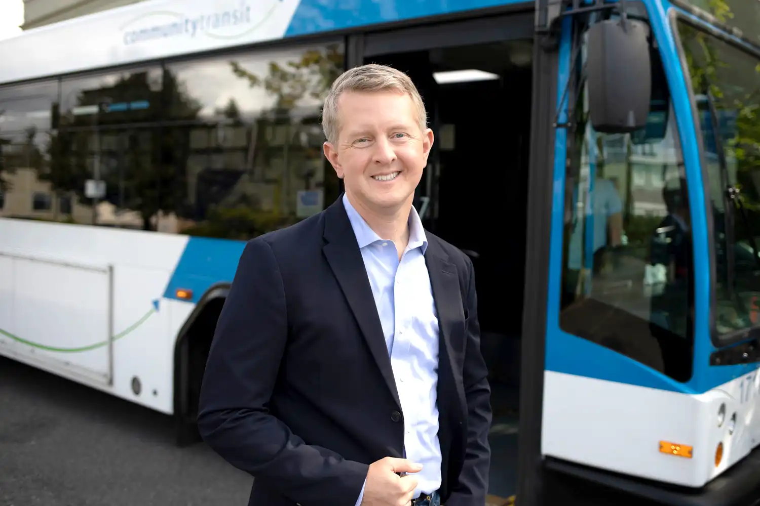 Ken Jennings, host of The Transit Effect, standing in front of a bus