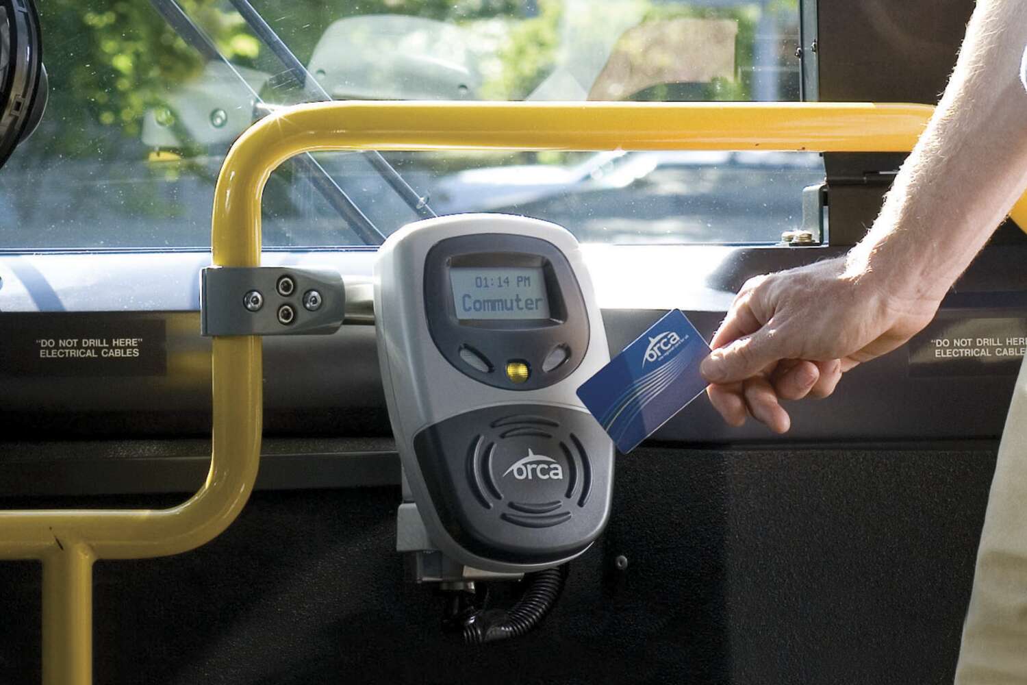 Commuter taps ORCA card on the bus reader