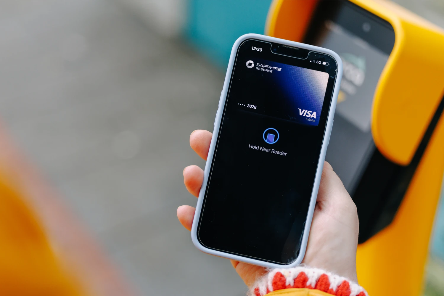 a rider paying their transit fare at an ORCA card reader using a credit card saved to their phone