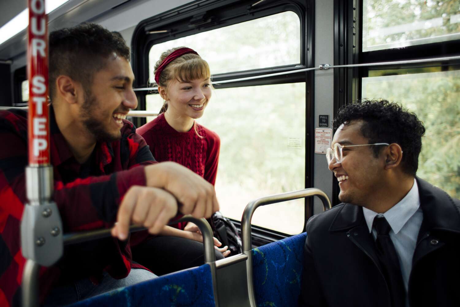 Ride Free Week three riders smiling and chatting while commuting on a bus