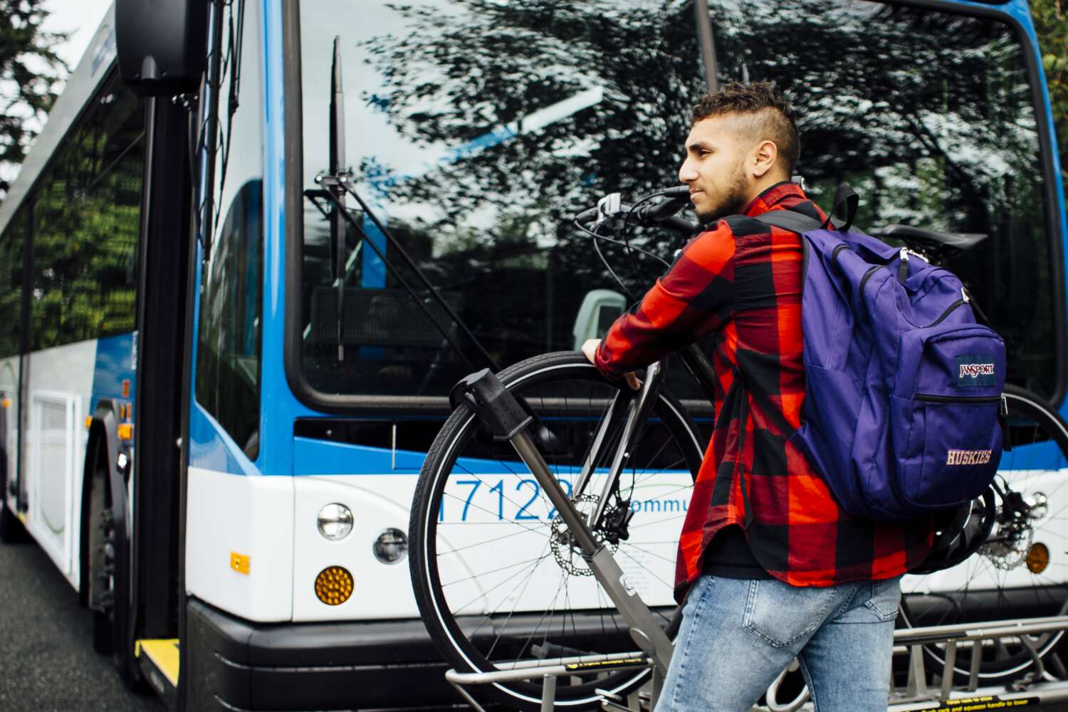 Rider loads his bike on the bike rack in front of the bus