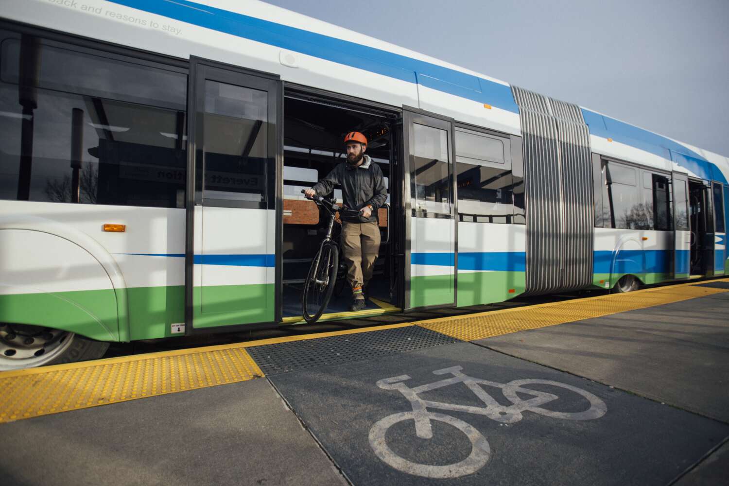Man exits Swift Green bus with bicycle