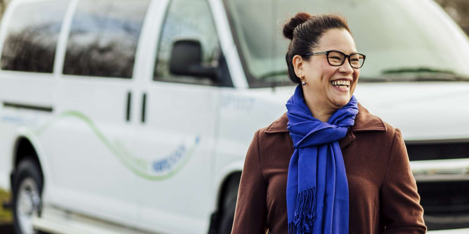 Smiling woman in front of Community Tranist Vanpool van