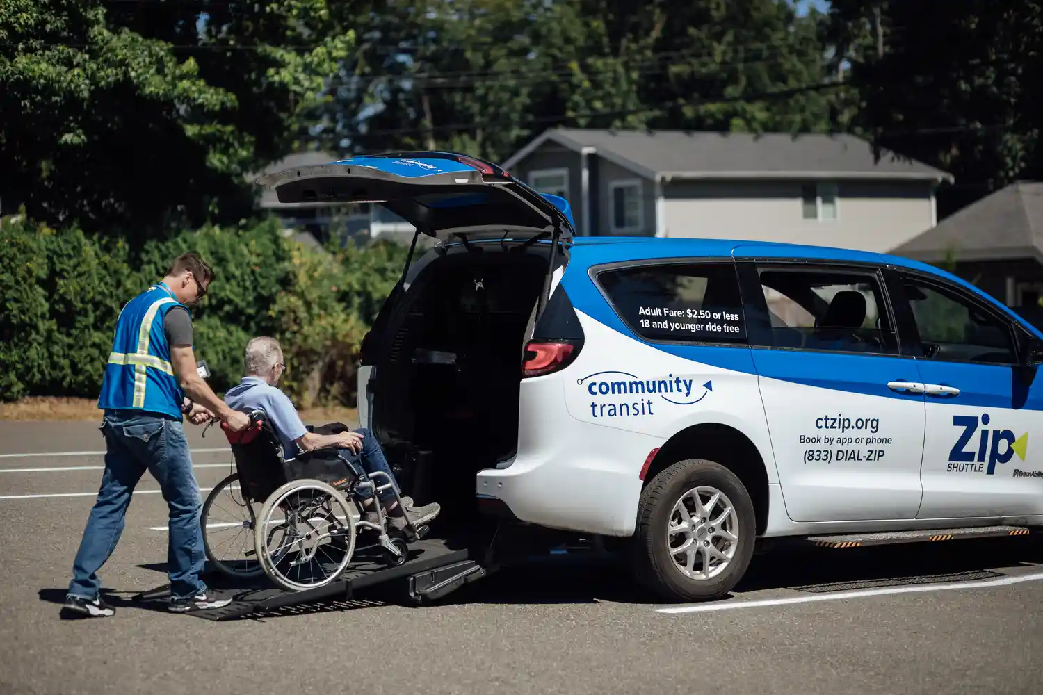 a rider in a wheelchair being assisted into an accessible Zip Shuttle rideshare van