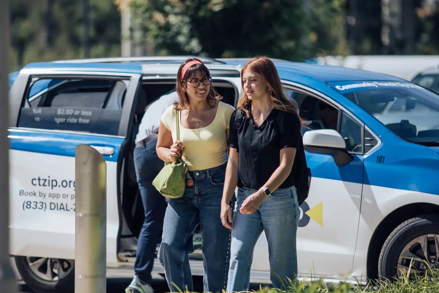 two riders after being dropped off by a Zip Shuttle rideshare van